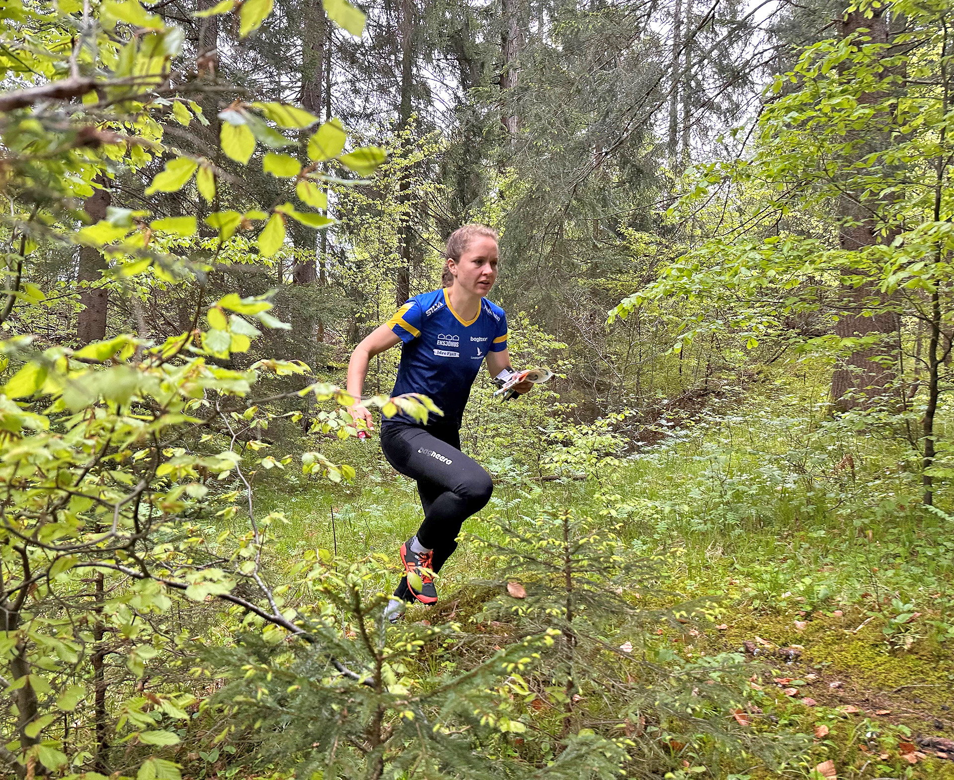Lisa Risby springer genom grönskande skog vid landslagsläger i Schweiz.