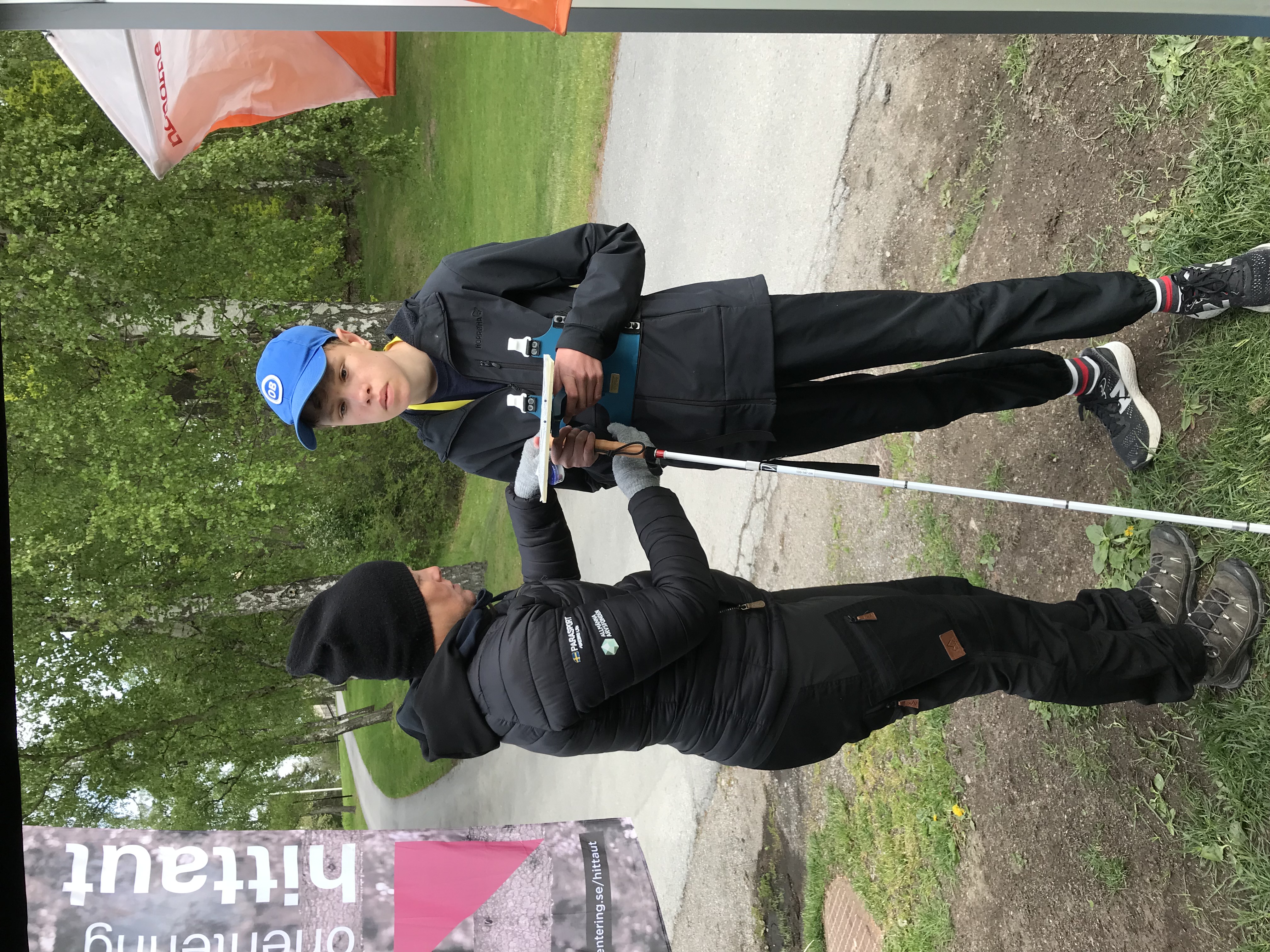 Dags för deltagaren med blindhet att ge sig ut på orienteringsbanan. Kartan sitter i ett skidorienteringskartställ och är taktil, alltså kännbar.