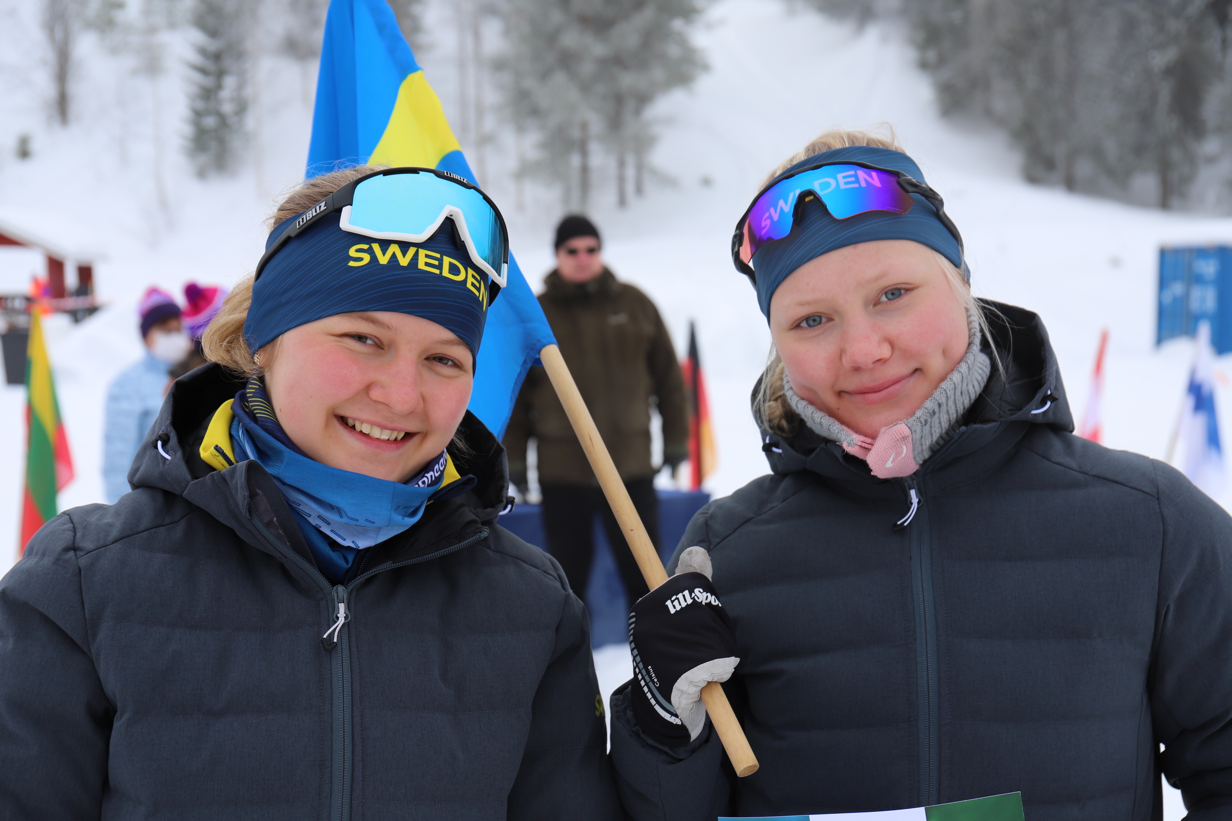 Två juniorer glada juniorer med svensk flagga under skidorienterings VM i Finland 