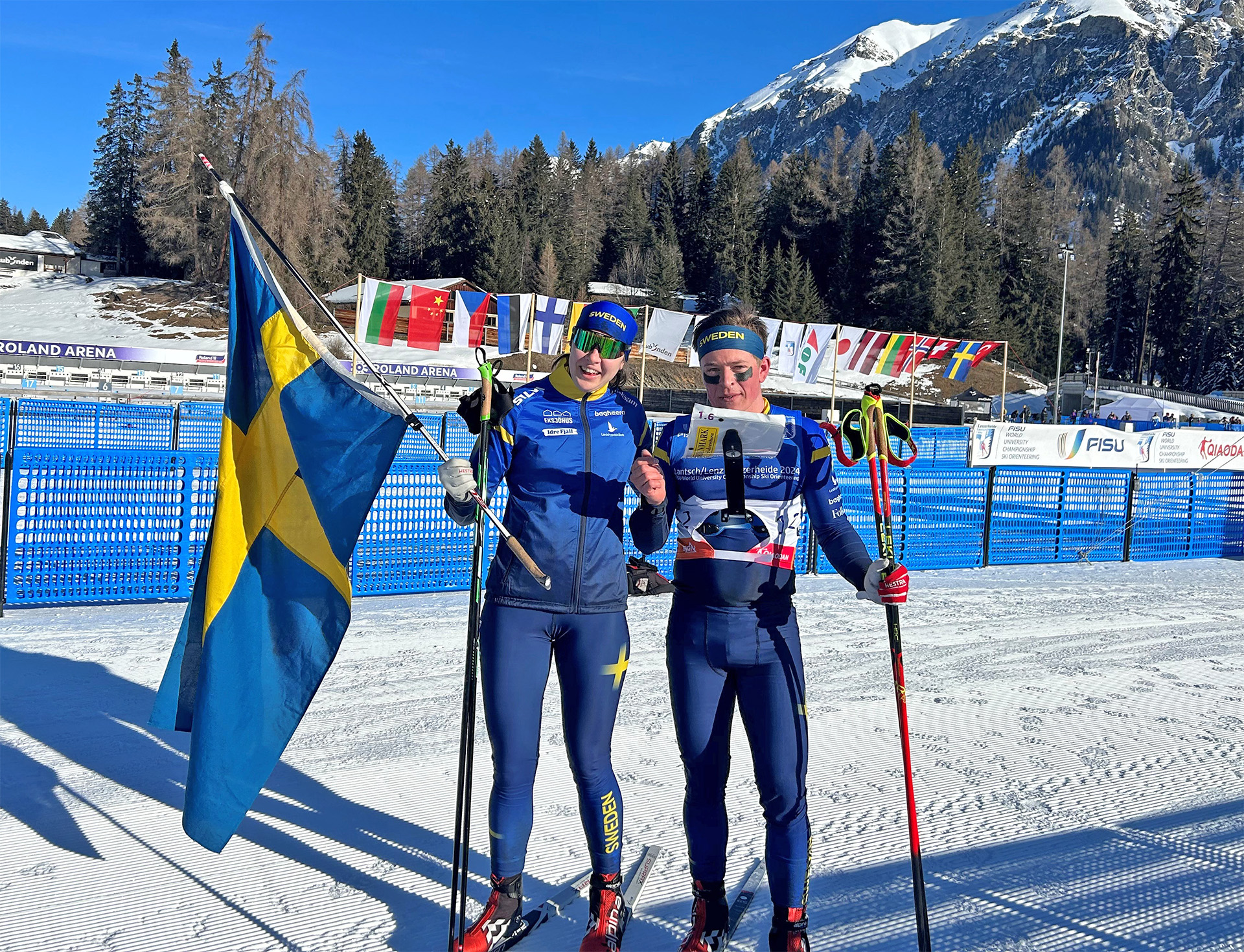Elin Schagerström och Jonatan Ståhl med svenska flaggan efter segern på mixstafetten vid Student-VM.